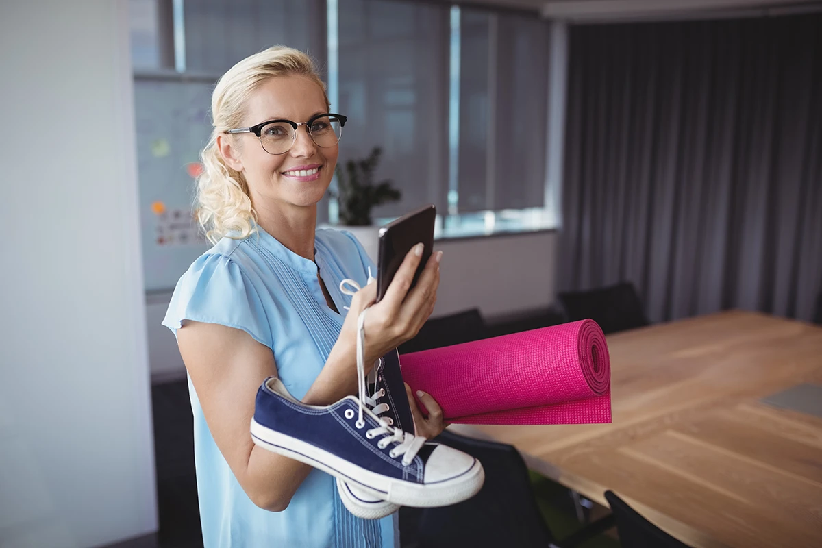Firmenfitness-Kurse - Frau mit Trainingsmatte